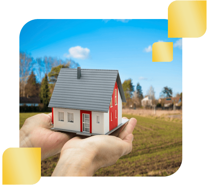 A person holding a small model house in their hands.