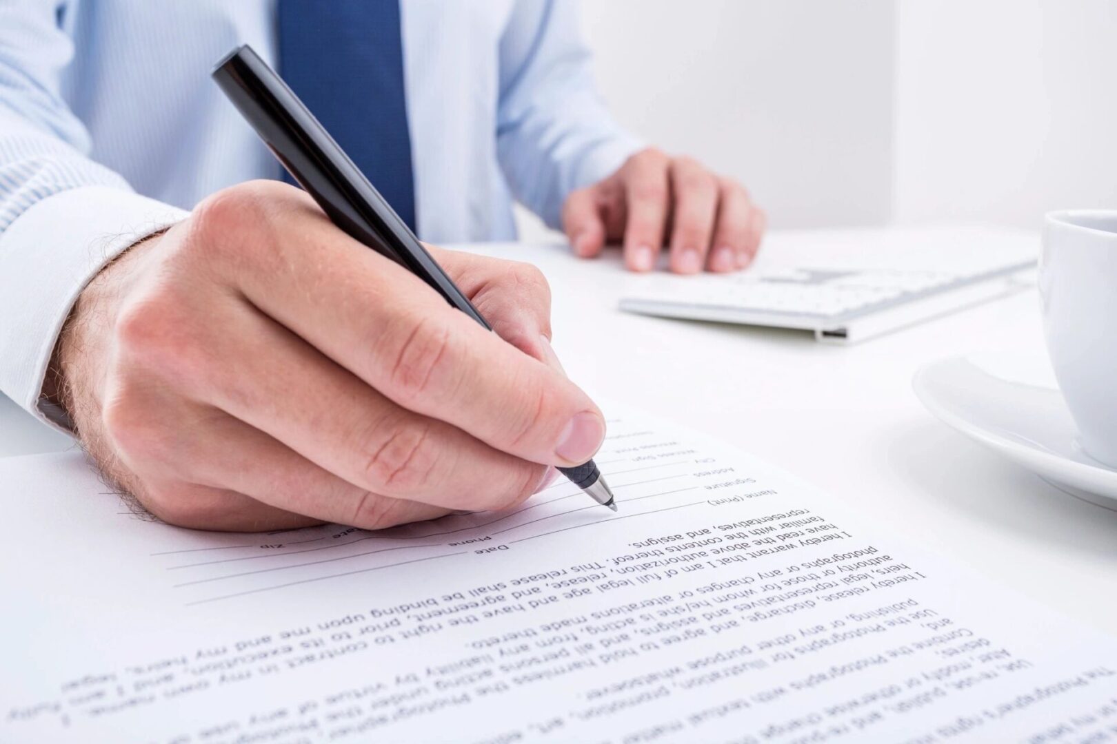 A person writing on top of a piece of paper.