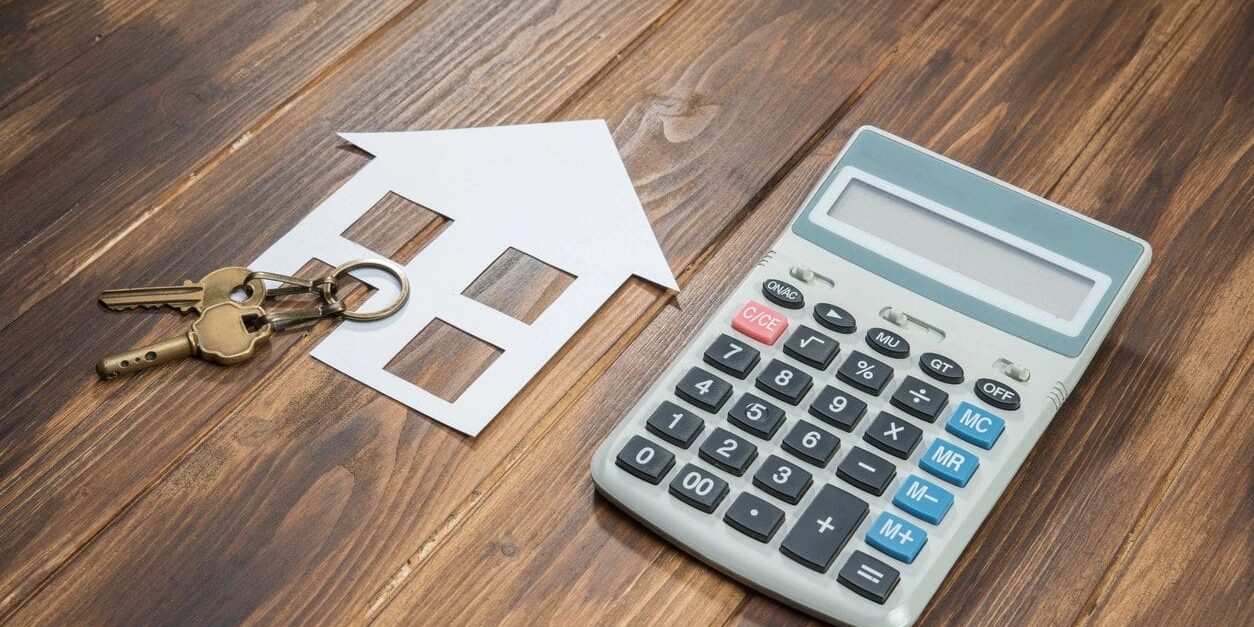 A calculator and key on top of a table.